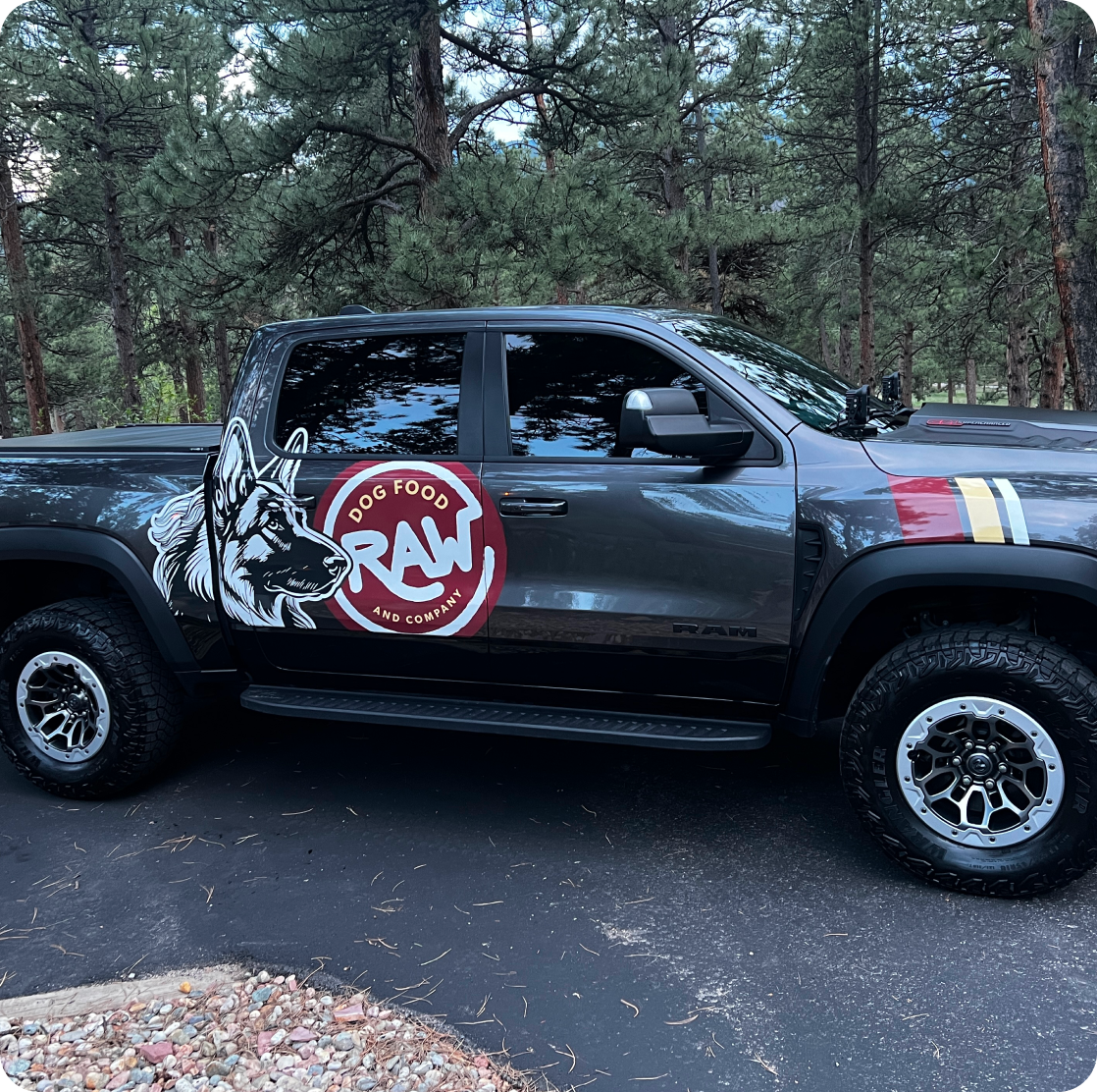 A Raw Dog Food and Co. delivery truck parked among pine trees