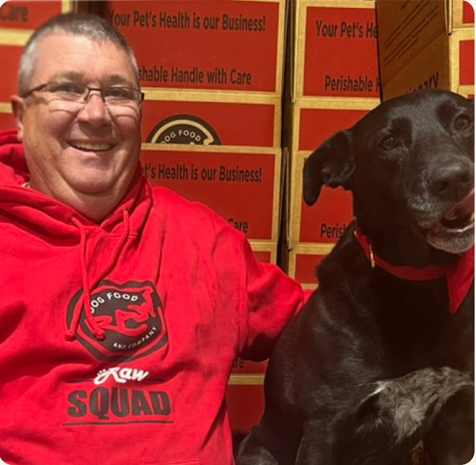 Brian Brandfas in a red Raw Squad hoodie beside a dark dog
